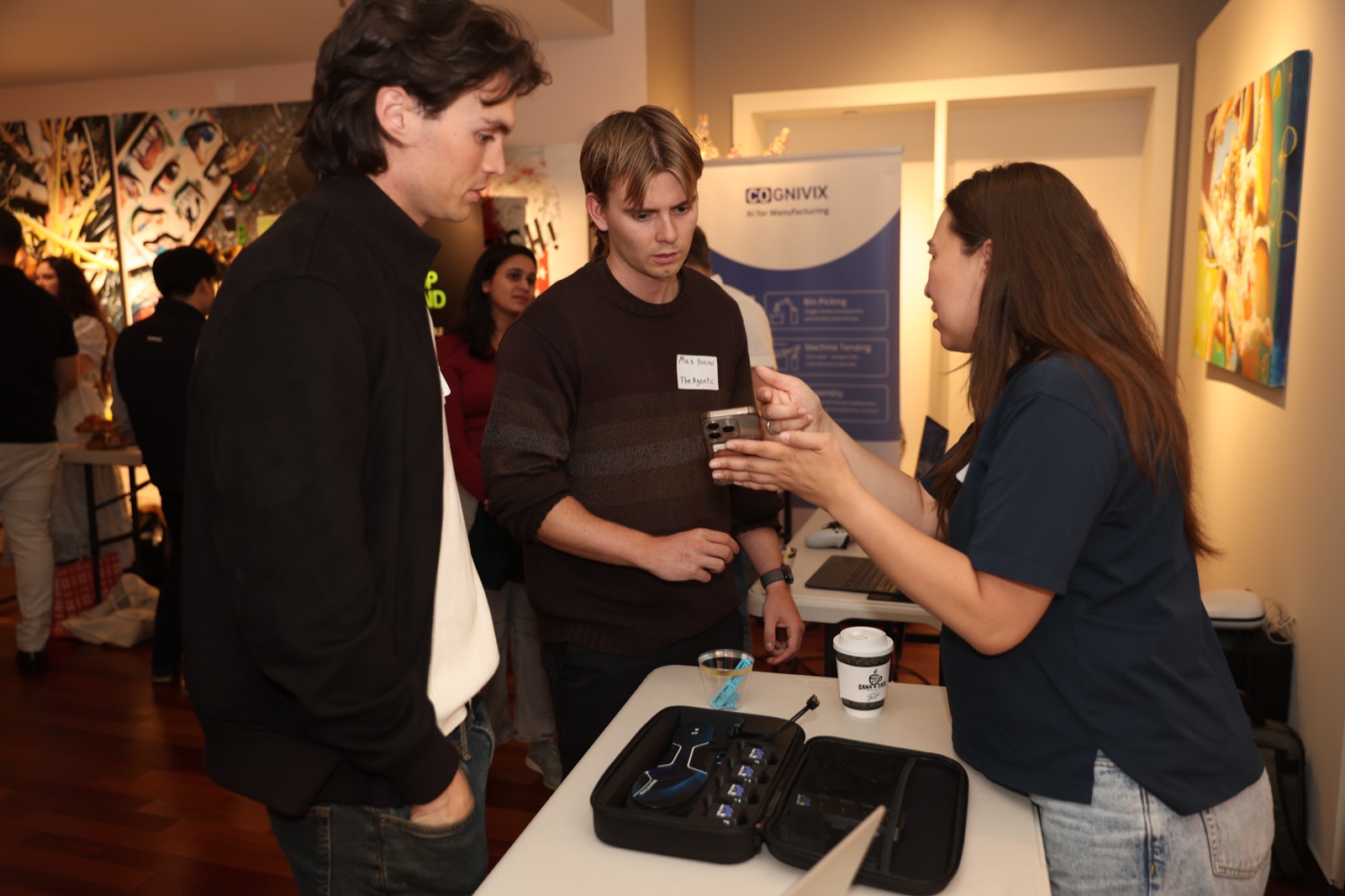 Guests speaking with a startup team after pitches